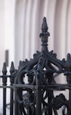 Close-up of a decorative wrought iron fence showing fine craftsmanship.