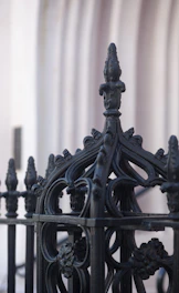 Close-up of an elegant, custom-designed luxury fence with intricate metalwork.