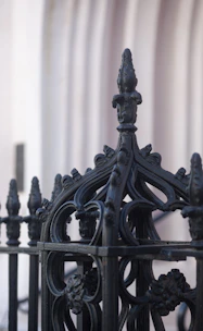 Close-up of an elegant, custom-designed luxury fence with intricate metalwork.
