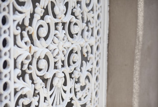 Close-up of a matte espresso wrought iron door with intricate scrollwork.