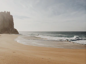 A serene beach scene at Varkala with golden sands and waves crashing against cliffs
