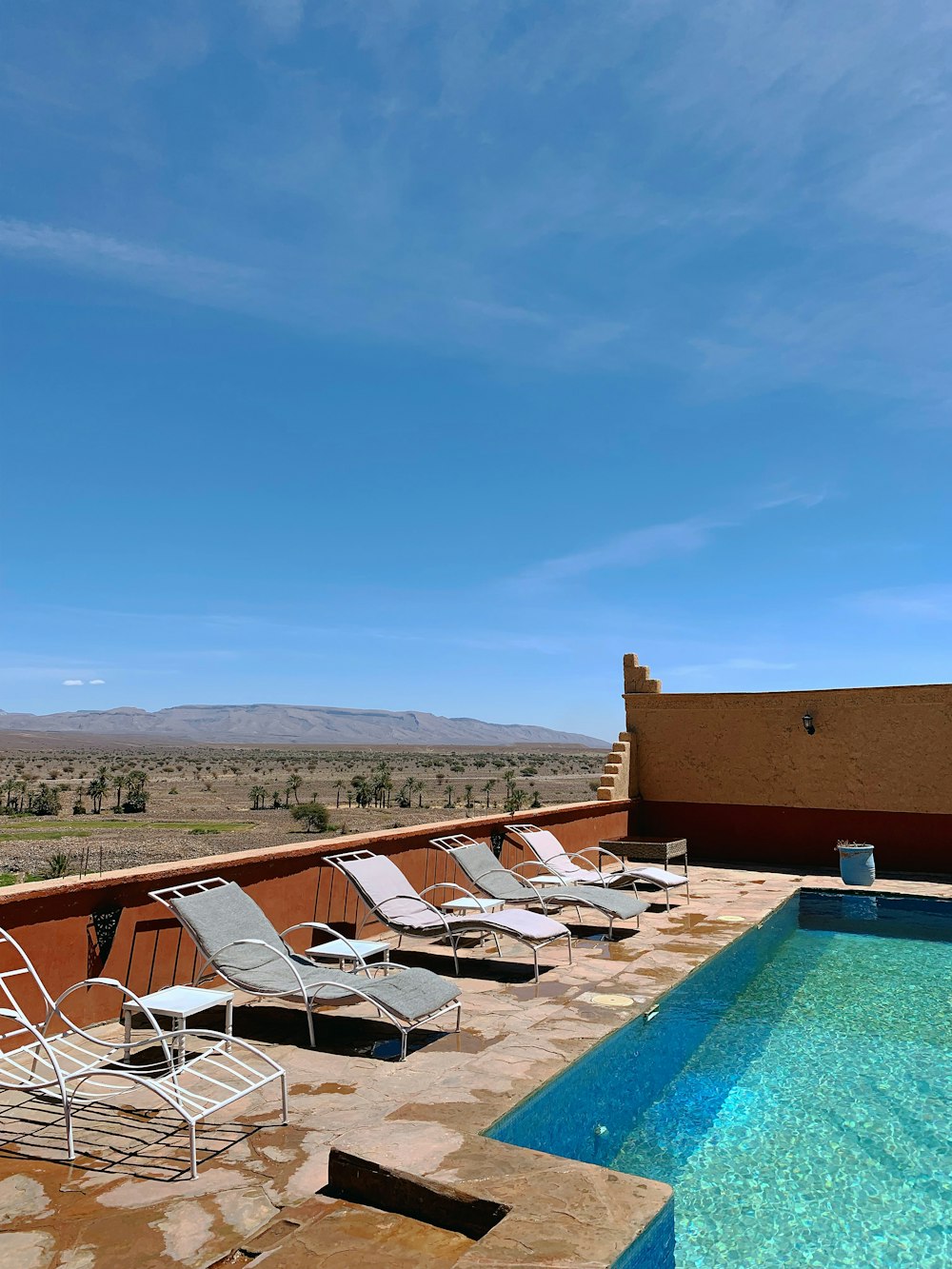 empty loungers beside pool