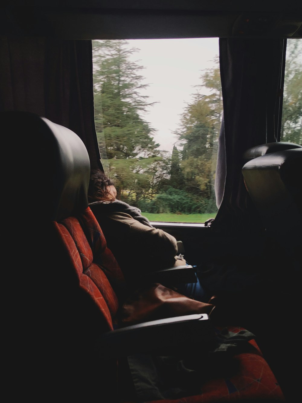 person sitting inside vehicle beside window during day