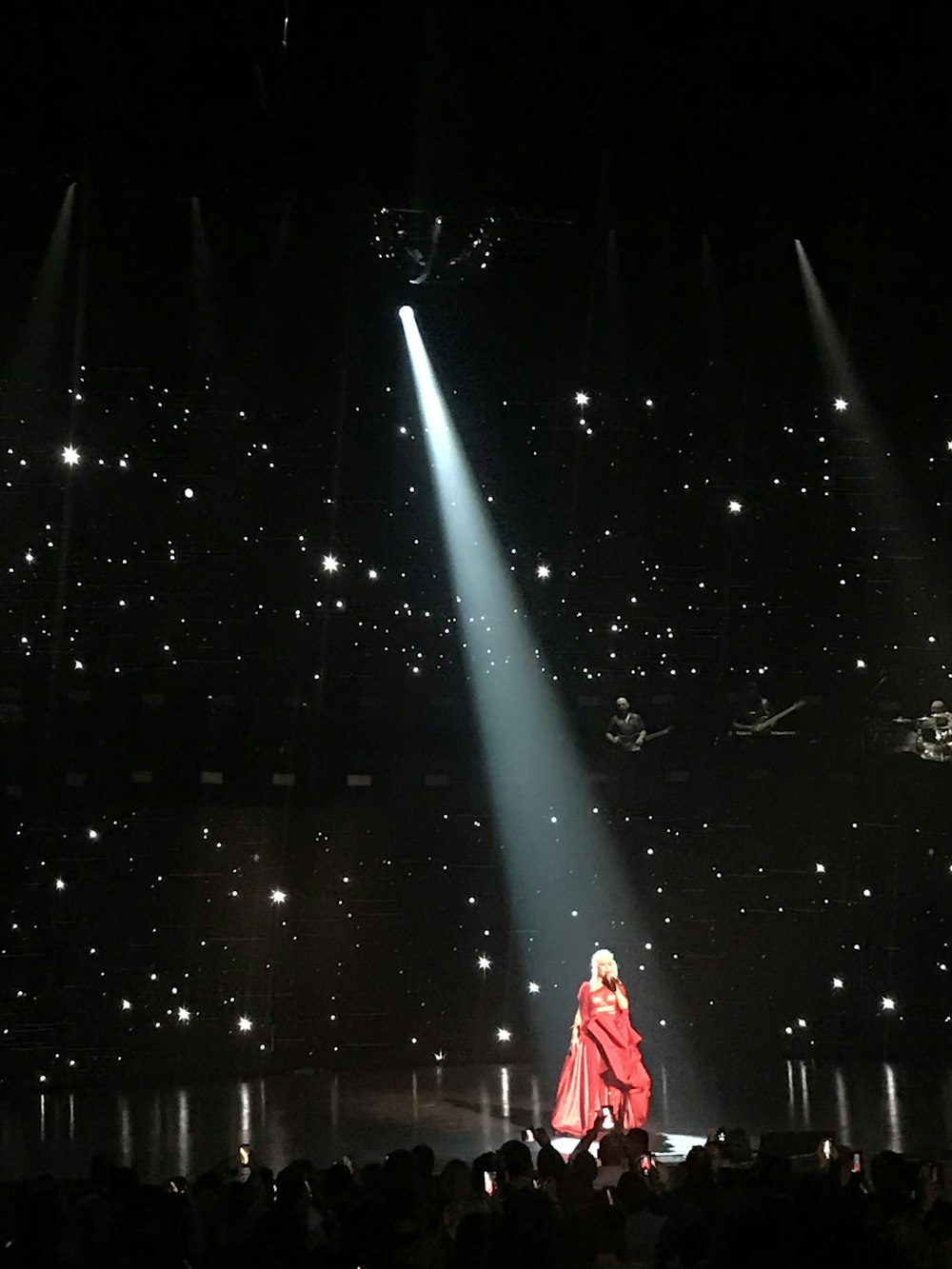 woman wearing red dress performing stage