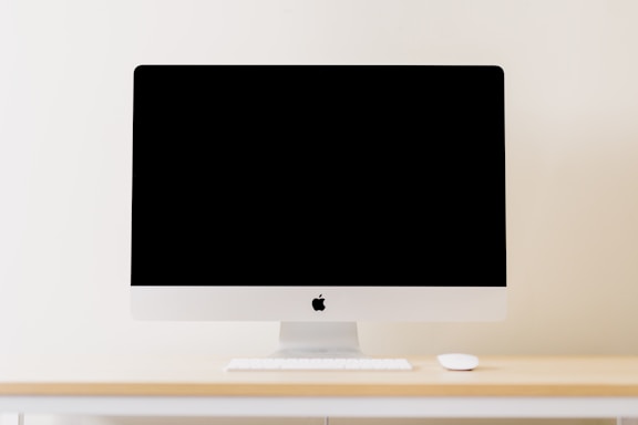 A clean, minimalist workspace featuring a sleek computer screen displaying a virtual staging project in progress.