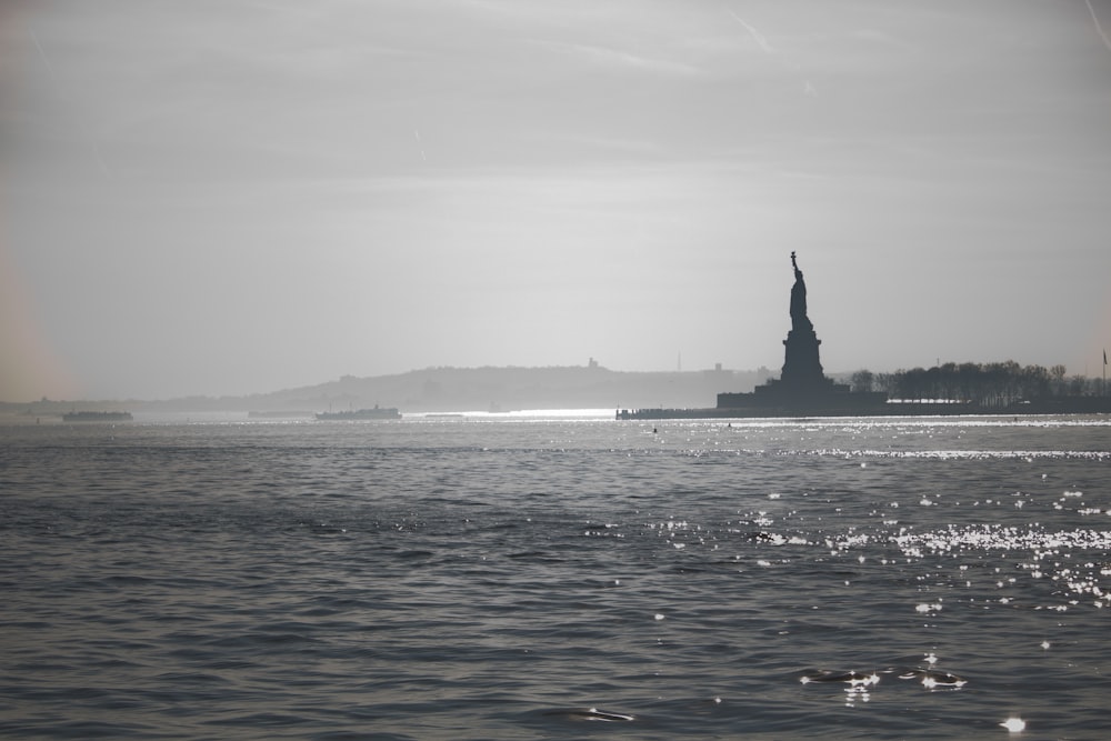 a large body of water with a statue of liberty in the background