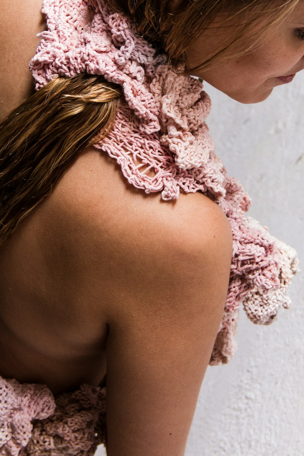 a close up of a woman wearing a pink top
