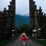 woman walking on pathway near green field