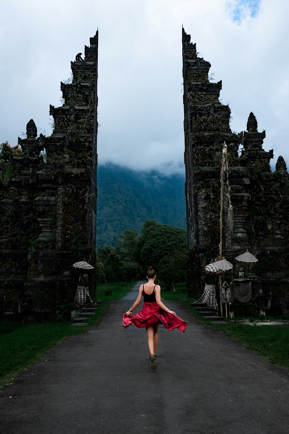 woman walking on pathway near green field