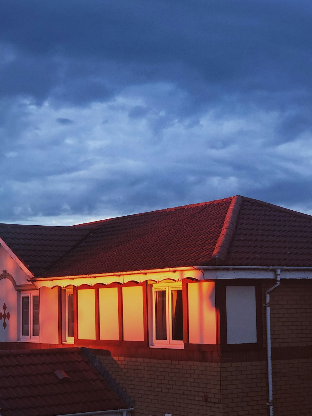 maroon house under cloudy sky