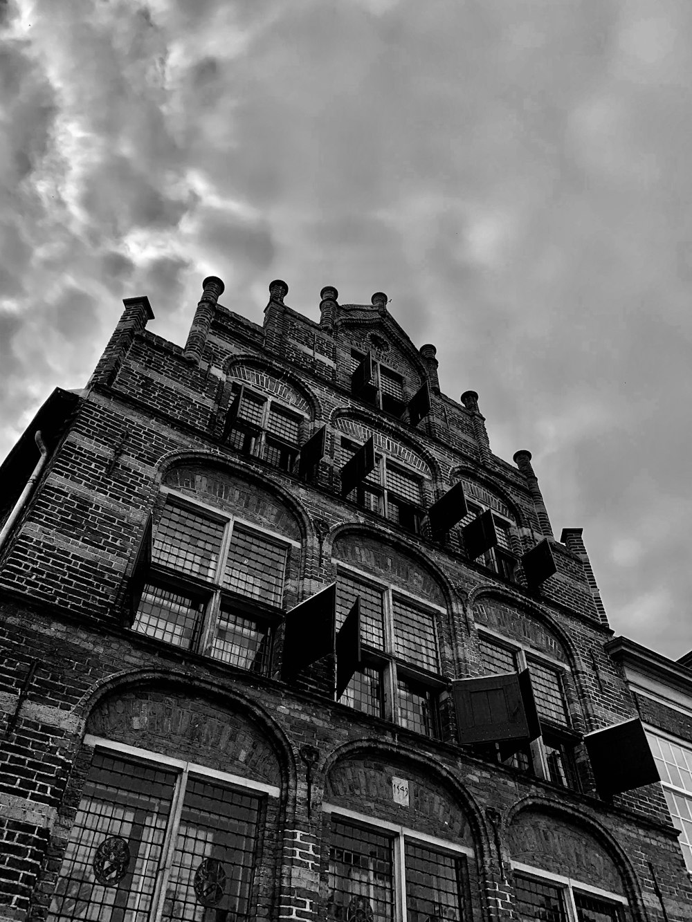 grey cloud hovering above antique brick building