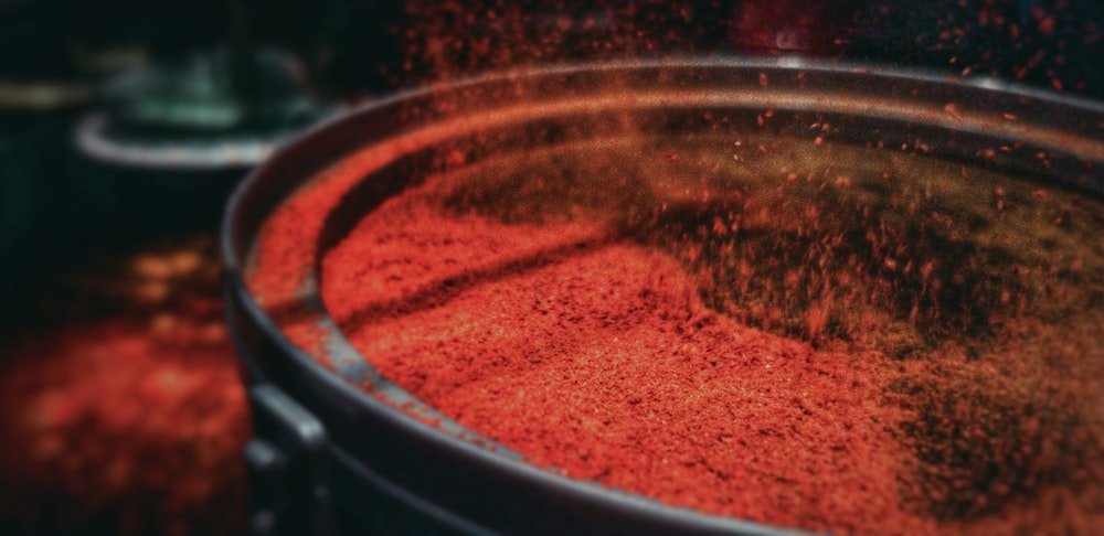 a large metal bucket filled with red powder