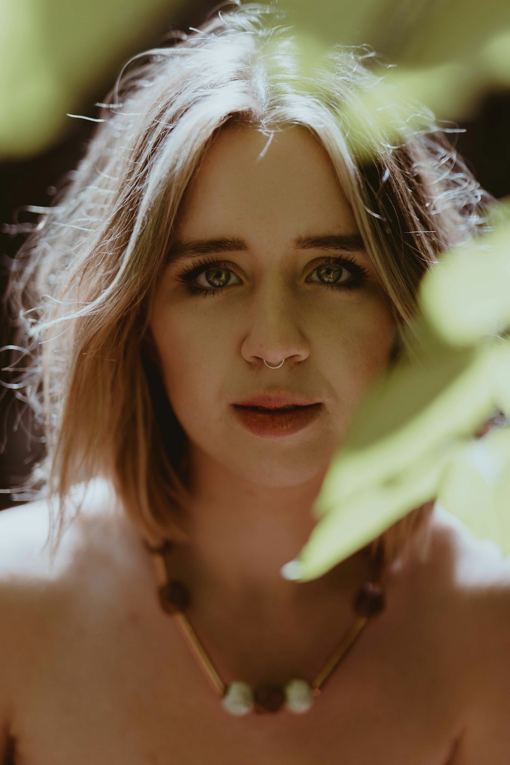 selective focus photo of woman wearing gold-colored necklace