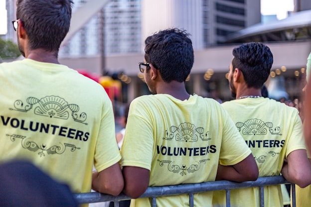three men wearing yellow Volunteers shirts