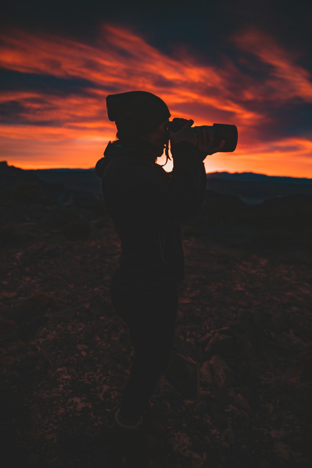 silhouette of person holding camera during golden hour