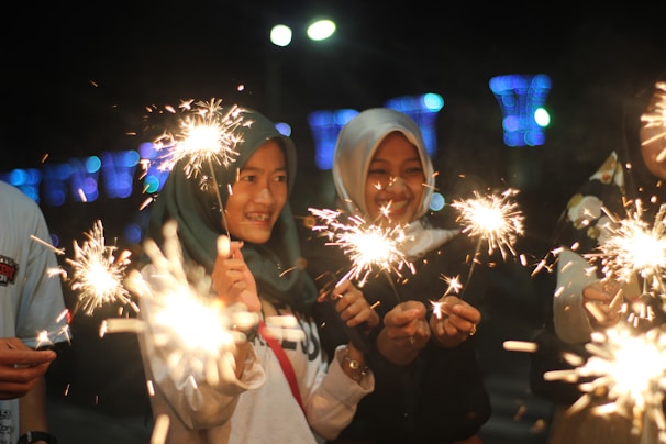 A family safely enjoying sparklers together on a festive evening.