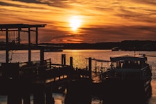 silhouette of dock and boats during sunset