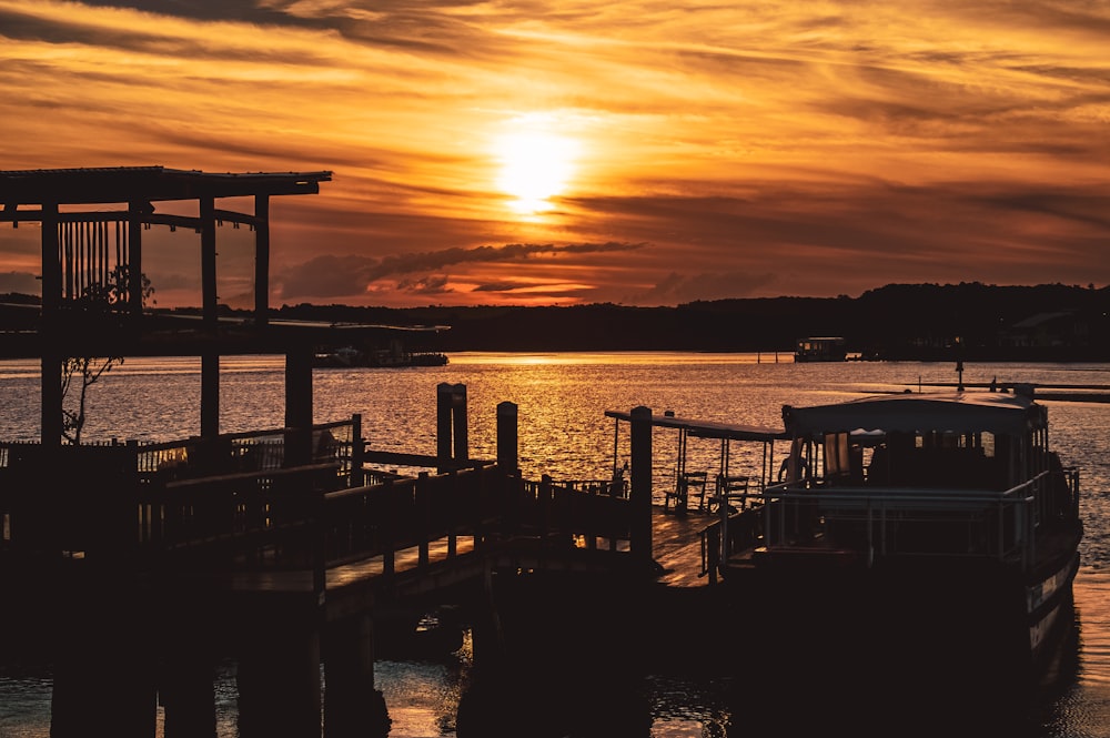 silhouette of dock and boats during sunset