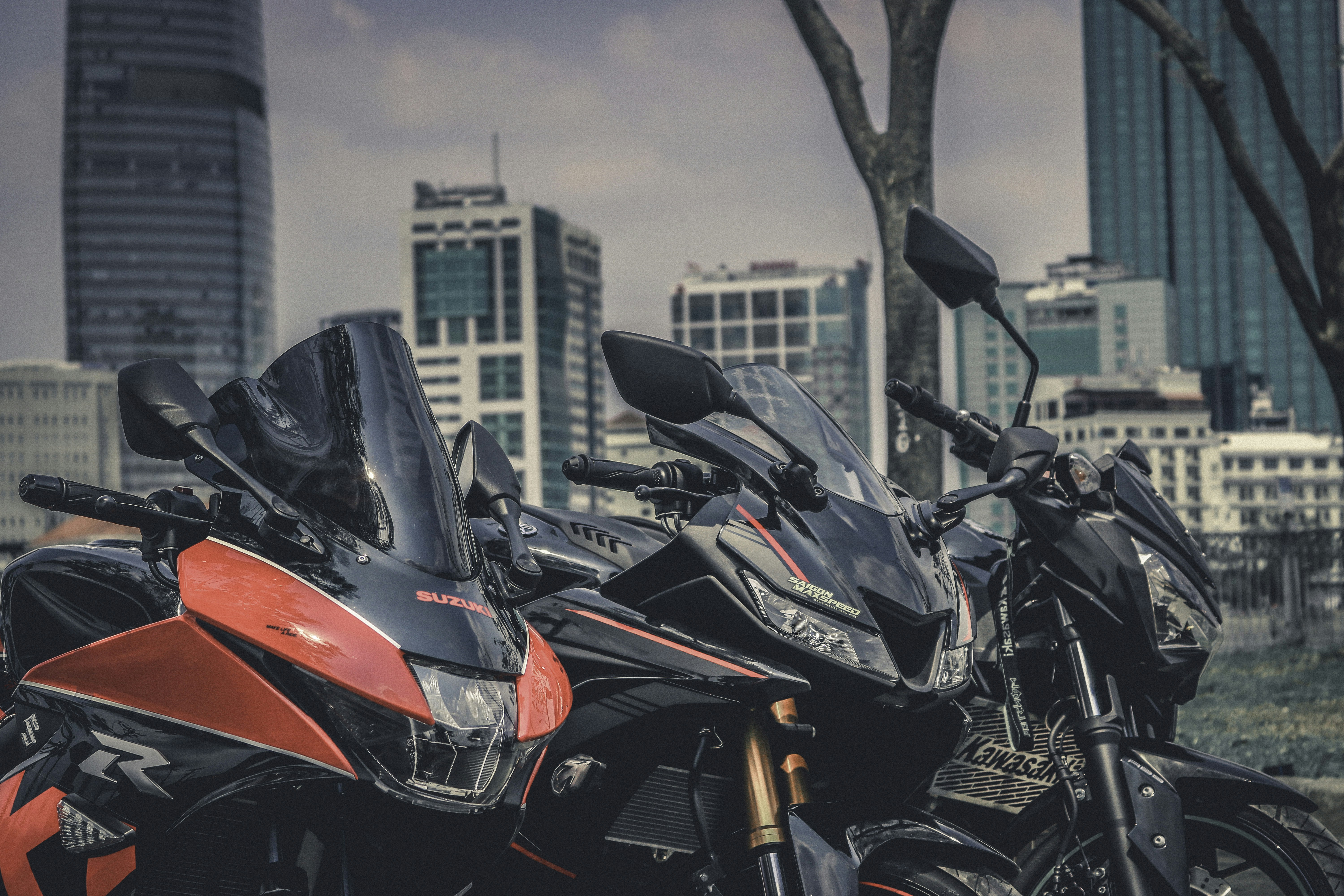 three parked motorcycles near buildings