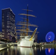 white boat on dock near city buildings during night time