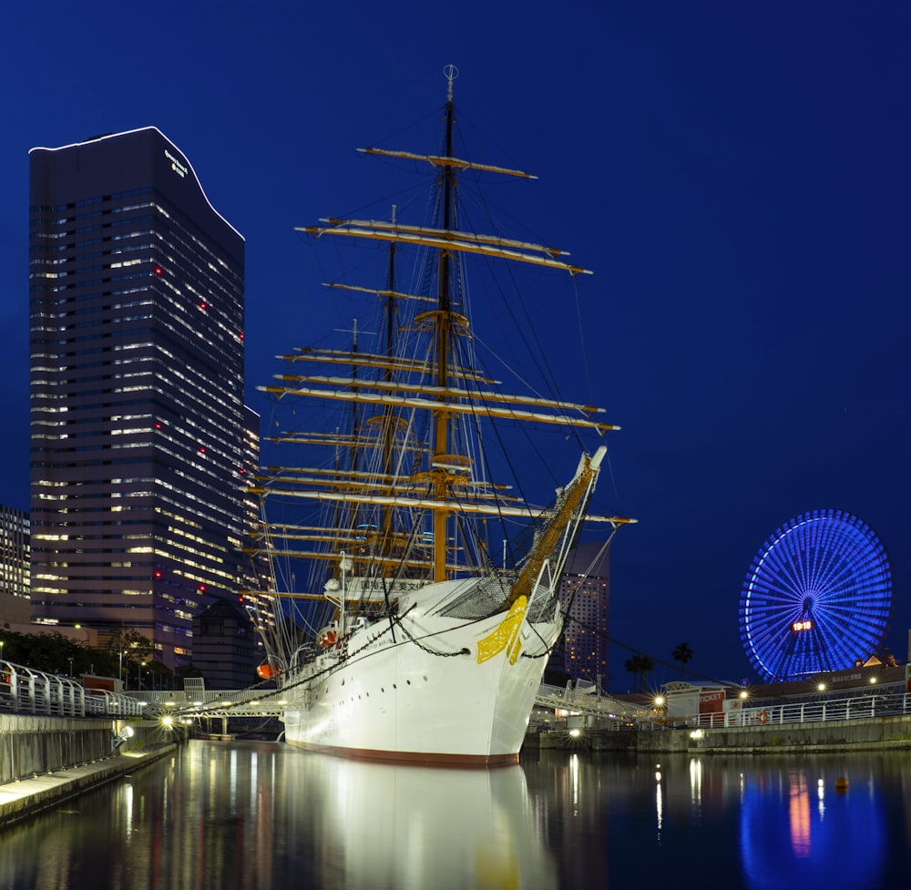 white boat on dock near city buildings during night time