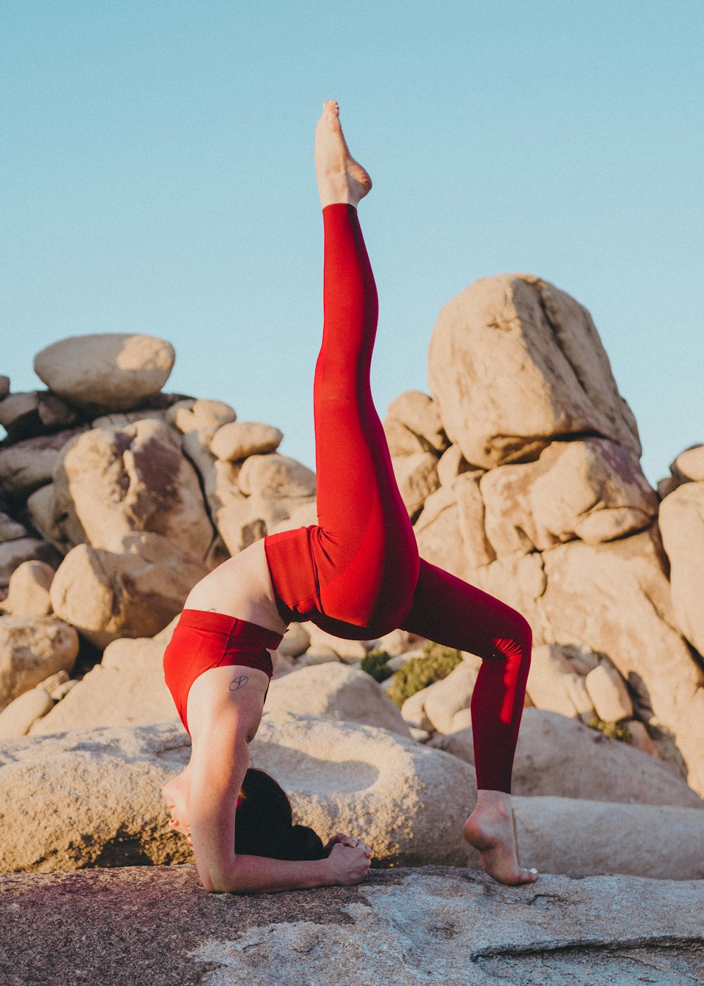 Frau macht tagsüber Yoga in der Nähe von Rock
