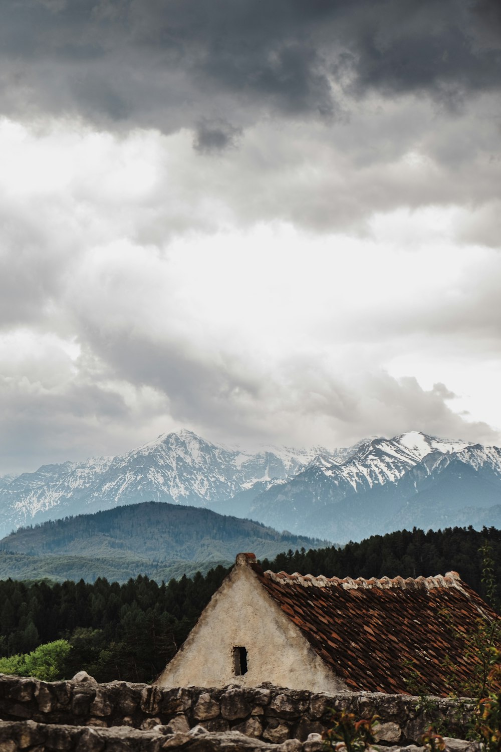 Casa branca e marrom perto de árvores e montanhas glaciares à distância