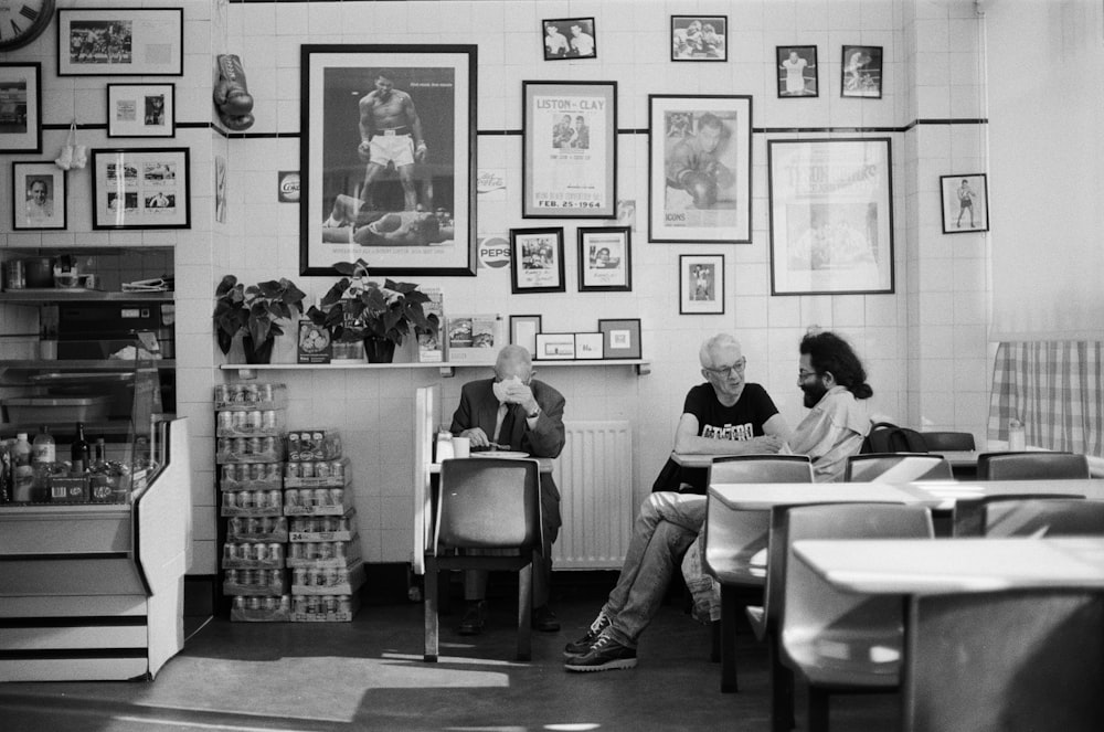 three men sitting on chair near wall