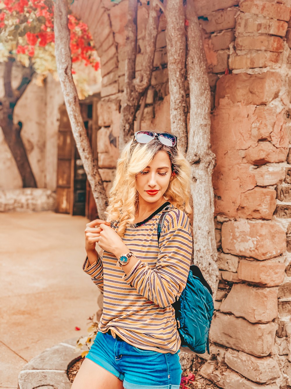 woman leaning on brick wall