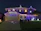 A cozy house decorated with elegant white and blue Christmas lights, with a smiling family enjoying the view.