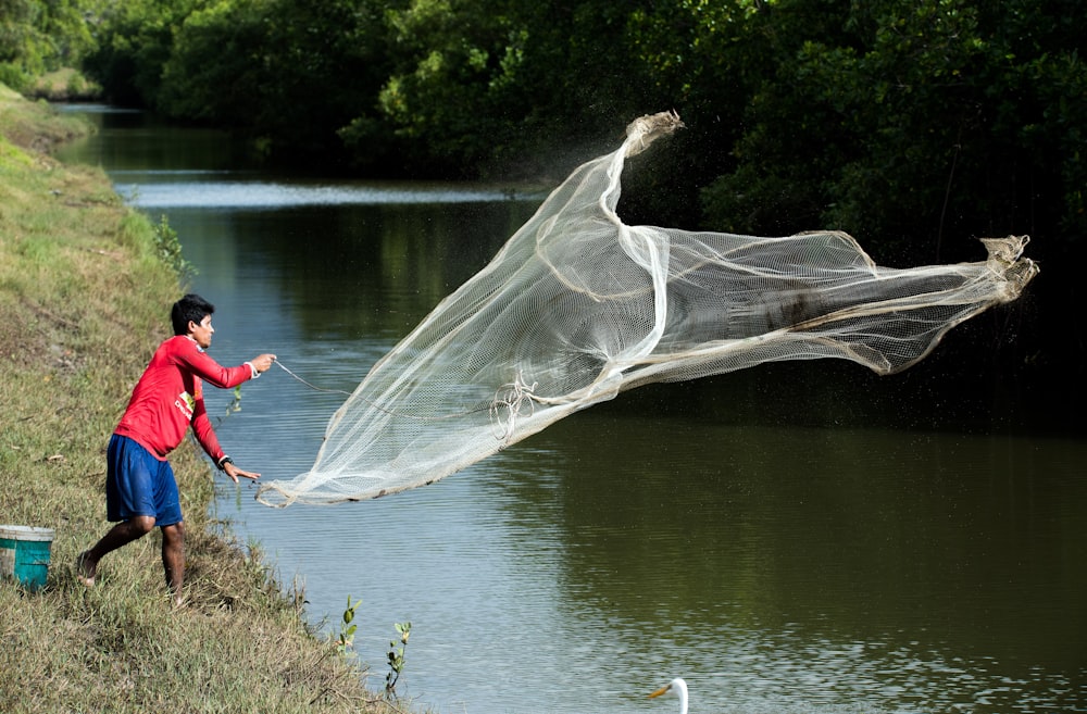 hombre lanzando red de pesca blanca