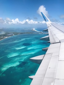 the wing of an airplane flying over the ocean