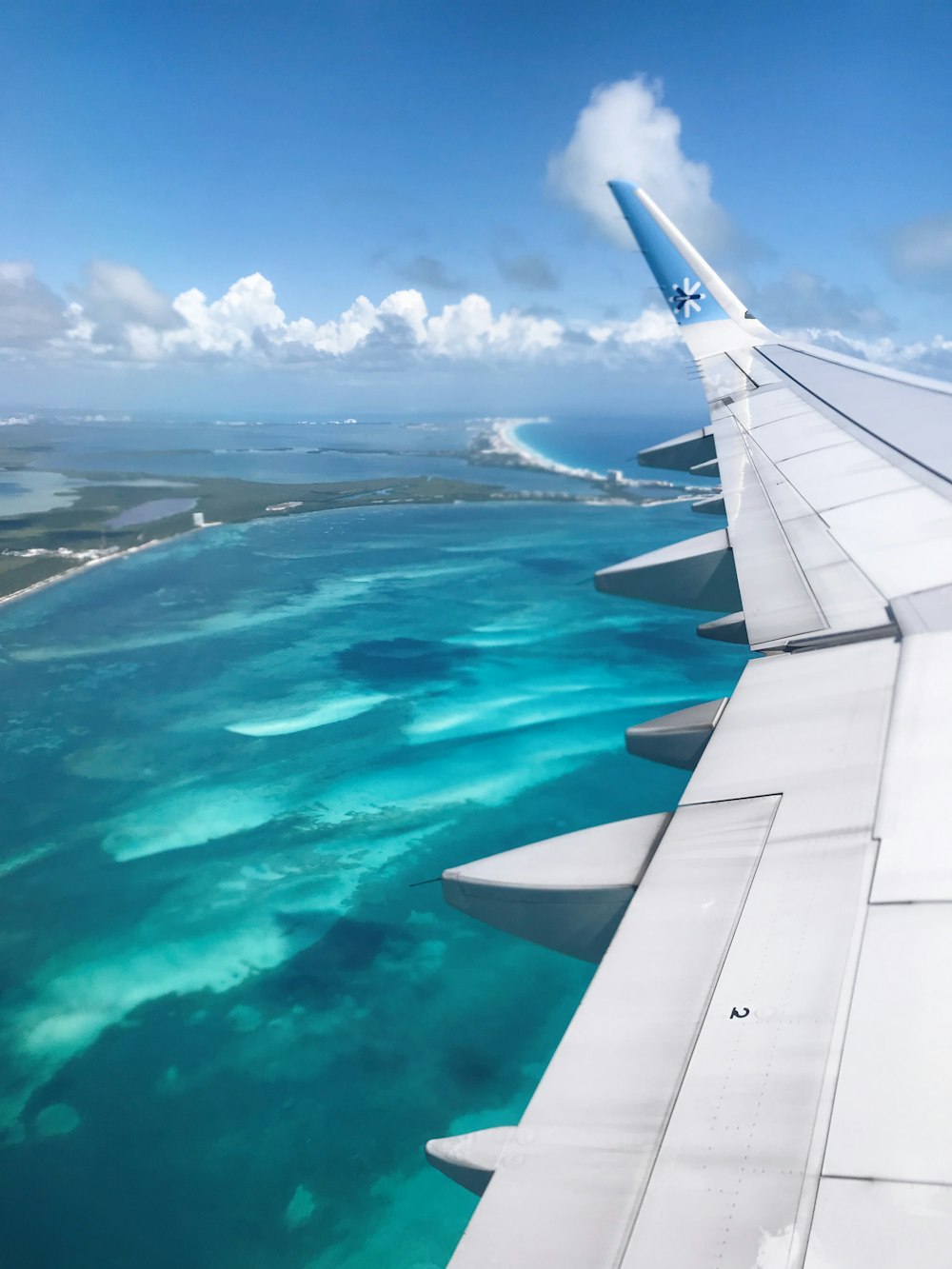 the wing of an airplane flying over the ocean