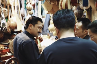 four people standing in front of guitar stall