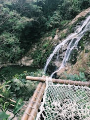 white mesh hammock beside falls