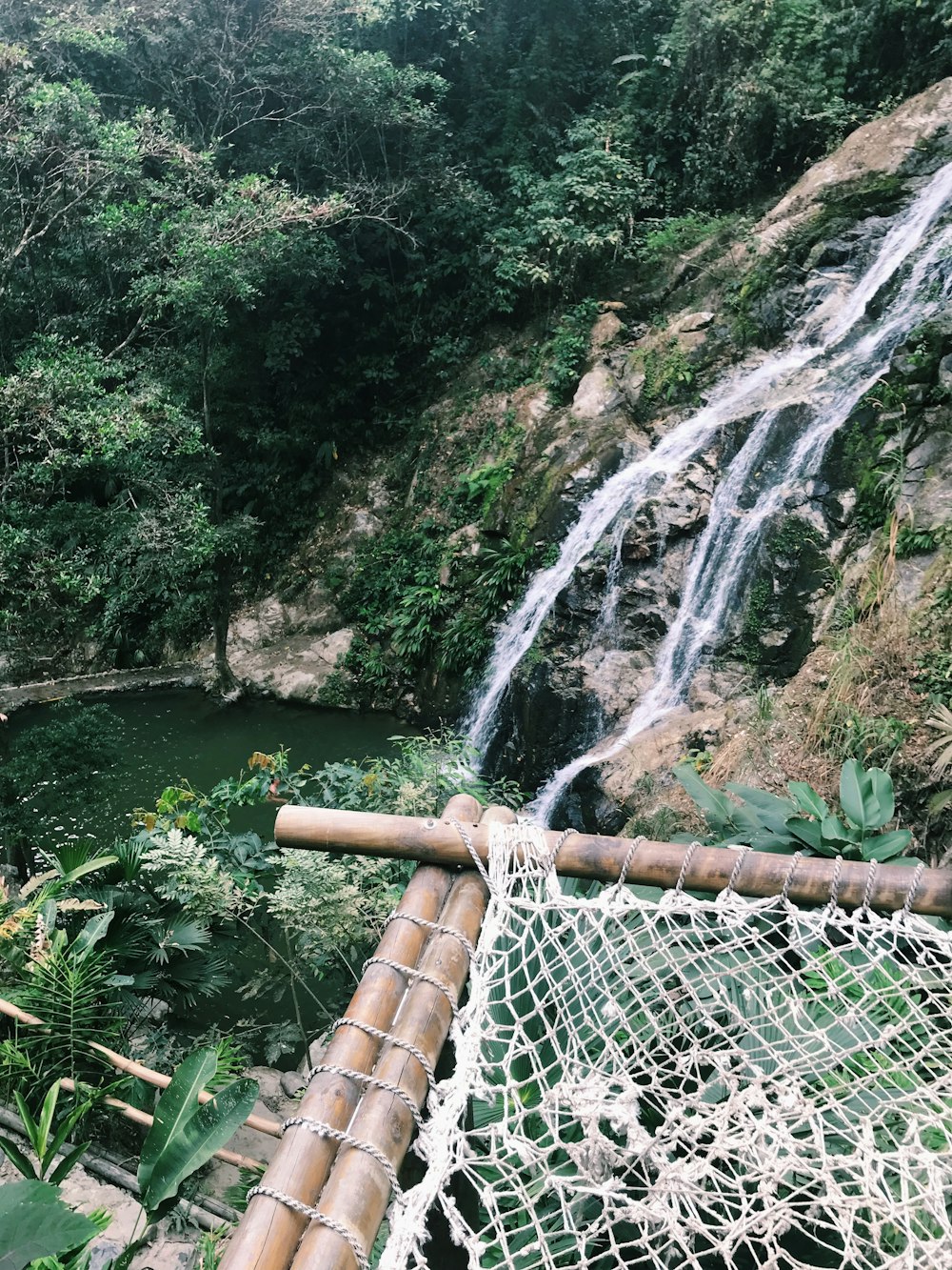 white mesh hammock beside falls