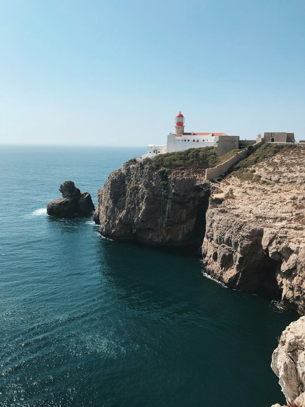 Edifício branco e laranja ao lado da costa durante o dia