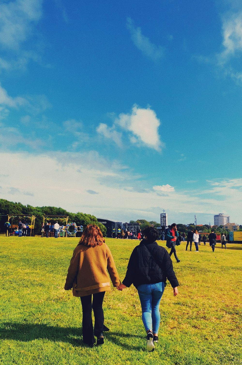 two women walking on grass field