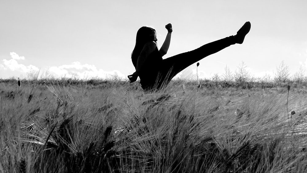 silhouette of photography of woman kicking on grass during daytime