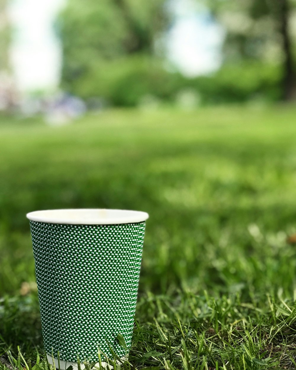 잔디밭에 녹색과 흰색 솔로 컵