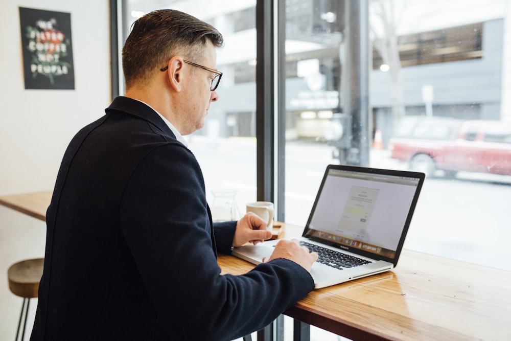 man wearing blue suit in front of MacBook Pro