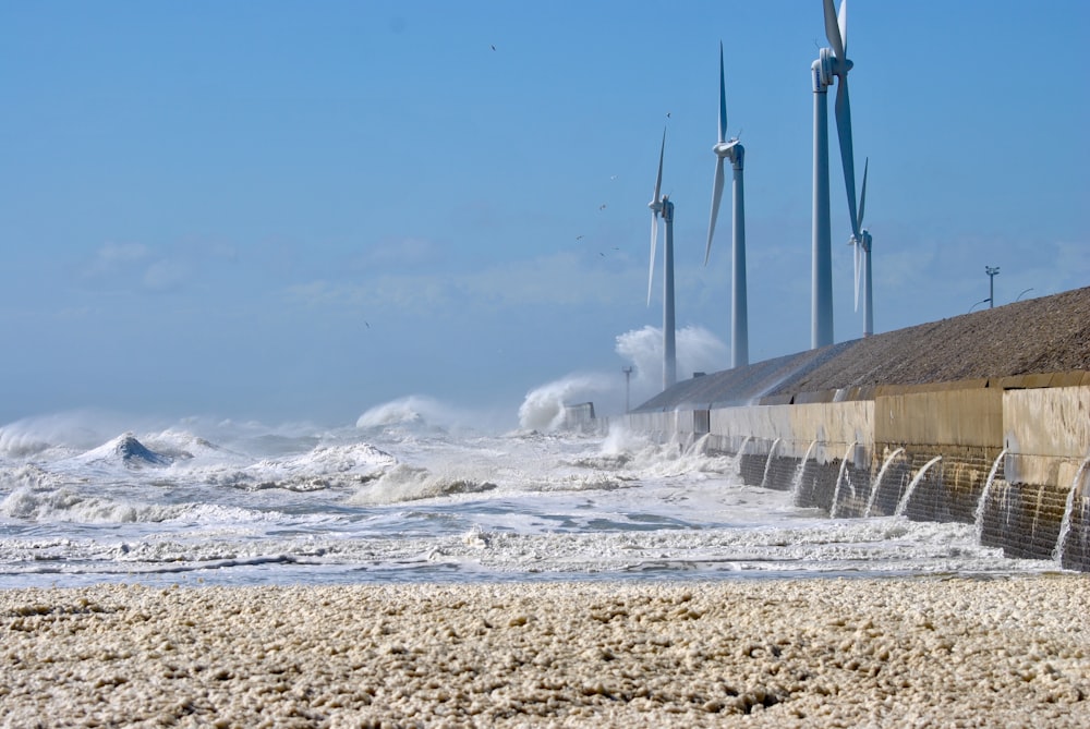 Photographie des vagues de l’océan s’écrasant sur un mur de béton gris pendant la journée