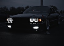 A sleek black car gleaming under bright lights after a detailed wash.