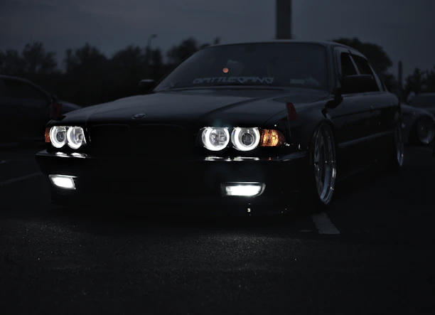 A sleek black car parked under soft lighting, showcasing polished tires and shiny ceramic coating.