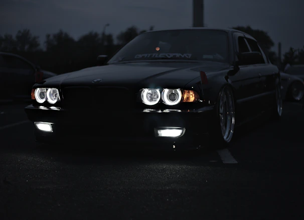 A sleek black supercar with gold accents parked under cinematic lighting, reflecting glossy shadows.