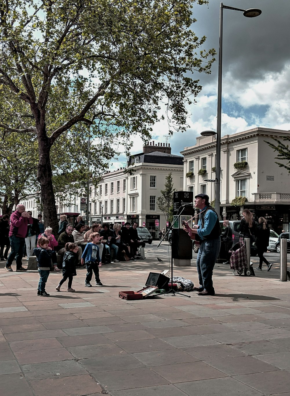man playing guitar surrounded with people