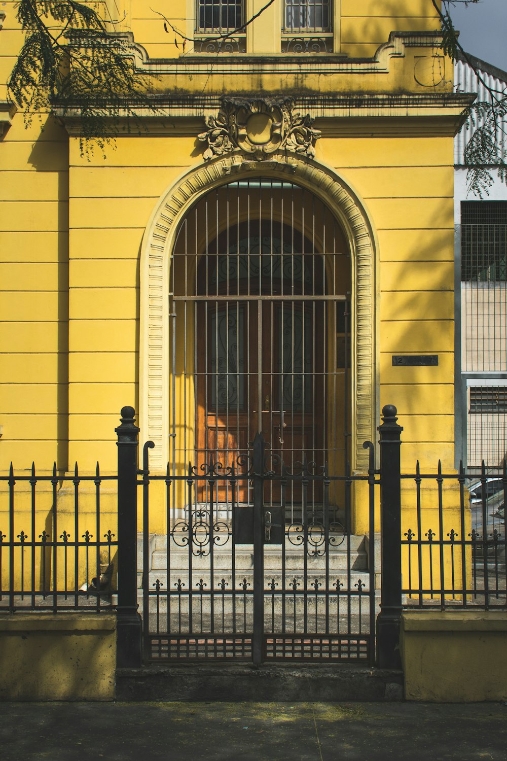 black steel gate across yellow building