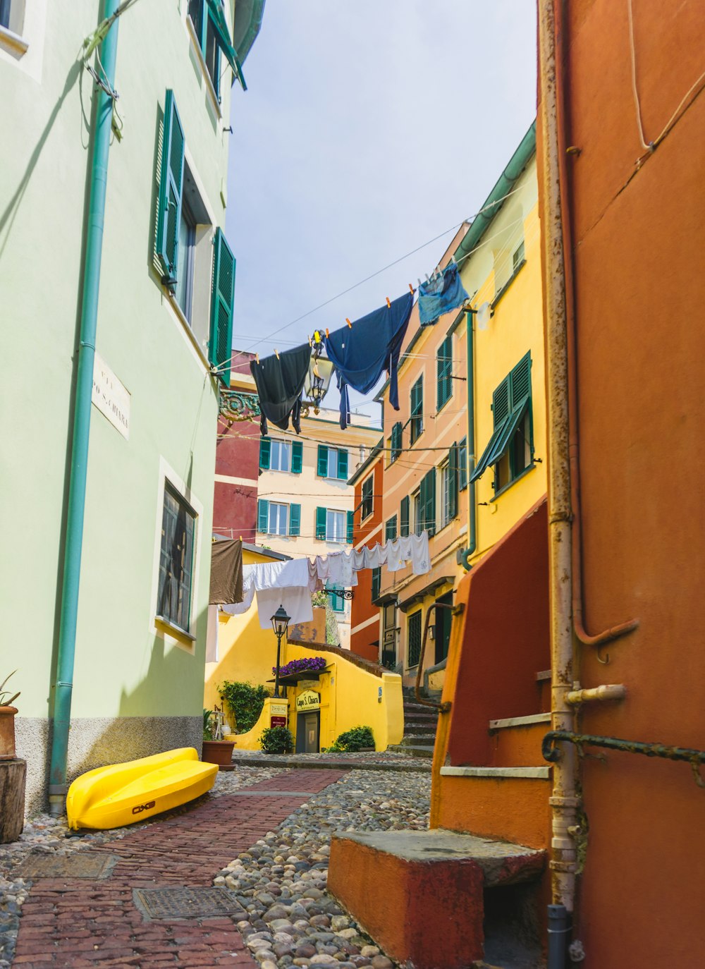 a narrow cobblestone street with a yellow banana laying on the ground