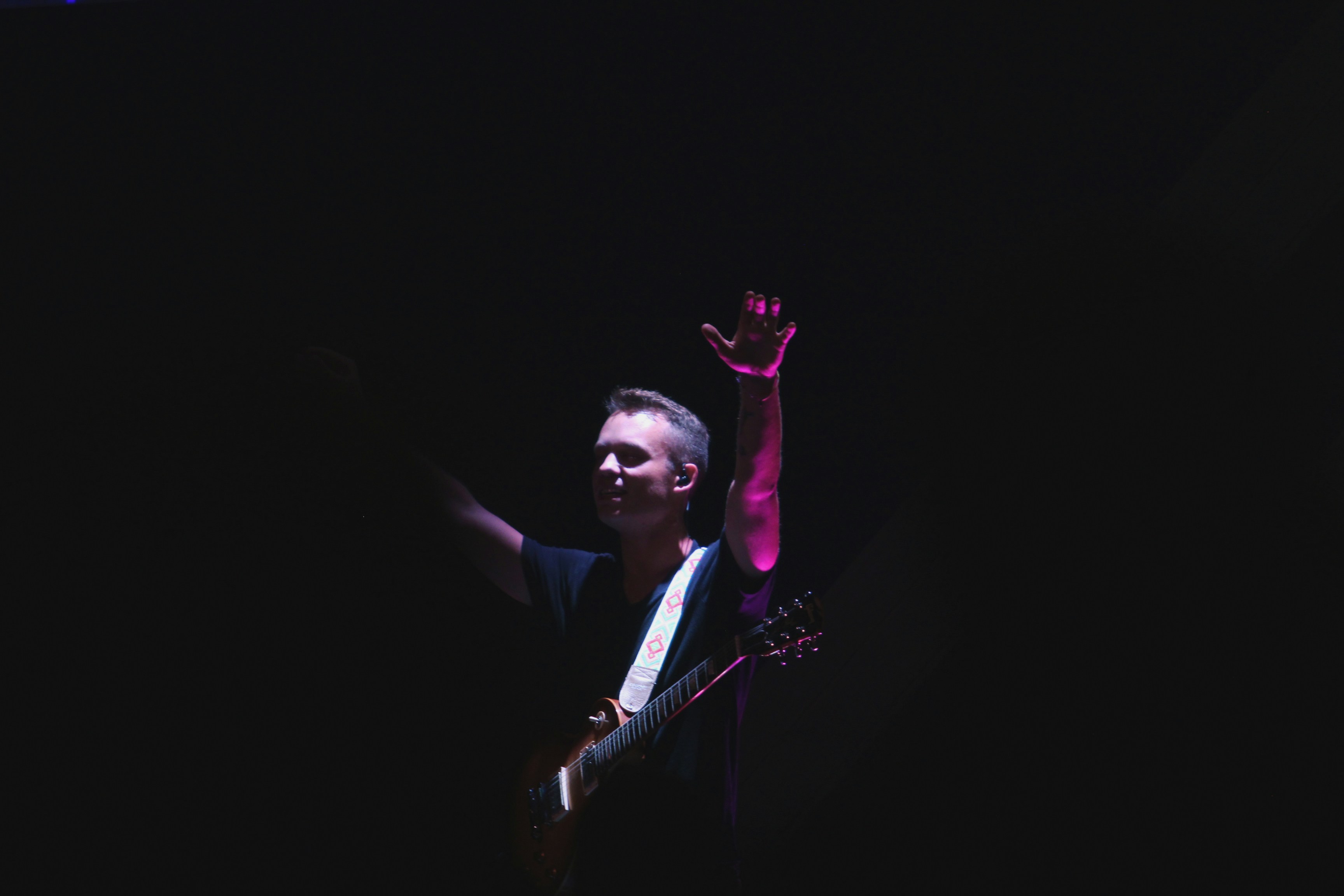 man in black crew-neck t-shirt holding guitar