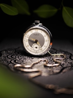 An elegant vintage pocket watch with delicate filigree details displayed on aged wood.